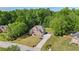 Aerial view of the brick home surrounded by meticulously maintained landscaping and mature trees at 1213 Blue Springs Dr, Loganville, GA 30052