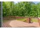 Expansive back deck offers a serene view of the lush, wooded backyard at 1213 Blue Springs Dr, Loganville, GA 30052