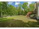 Lush backyard with mature trees, a private fence, and a wooden deck with stairs at 1213 Blue Springs Dr, Loganville, GA 30052