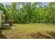 Expansive backyard with a wooden deck, lush green lawn, and mature trees at 1213 Blue Springs Dr, Loganville, GA 30052