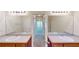 Bright bathroom featuring double sinks, stone counters, wood cabinets and a walk-in shower at 1213 Blue Springs Dr, Loganville, GA 30052