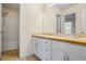Bright bathroom featuring a double sink vanity, large mirror, and a shower-tub combo with white tile surround at 1213 Blue Springs Dr, Loganville, GA 30052