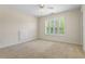 Bedroom with large window, neutral carpet, and access to bathroom at 1213 Blue Springs Dr, Loganville, GA 30052