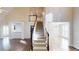 Inviting foyer with a staircase, wood floors, and views into the kitchen and living areas at 1213 Blue Springs Dr, Loganville, GA 30052