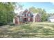Charming brick residence boasting a well-maintained lawn and beautiful trees creating a serene landscape at 1213 Blue Springs Dr, Loganville, GA 30052