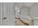 Ensuite bathroom features a large tub, white cabinets, a mirror, and laminate flooring at 1704 Yarborough Dr, Peachtree City, GA 30269