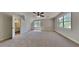 Bright bedroom with neutral carpeting and white walls features two windows and an ensuite bathroom at 1704 Yarborough Dr, Peachtree City, GA 30269