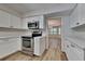Modern kitchen with white cabinets, stainless steel appliances, and wood-look floors at 1704 Yarborough Dr, Peachtree City, GA 30269