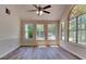 Bright room with many windows, wood-look floors, neutral colors and ceiling fan at 1704 Yarborough Dr, Peachtree City, GA 30269