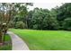 Expansive green lawn with mature trees and a walking path, perfect for outdoor enjoyment and recreation at 23310 Plantation Ne Dr, Atlanta, GA 30324