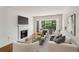 Bright living room with a fireplace, wood floors, and a balcony overlooking lush greenery at 23310 Plantation Ne Dr, Atlanta, GA 30324