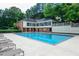 Community pool with ample lounge seating, perfect for relaxation, surrounded by mature trees and landscaping at 23310 Plantation Ne Dr, Atlanta, GA 30324
