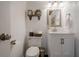 Charming half bathroom with white wood paneling, stylish fixtures, and a decorative shelf at 2566 Garrison Sw, Marietta, GA 30064