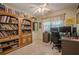 Cozy room with a ceiling fan, large bookcase, and a desk creating a comfortable workspace at 2566 Garrison Sw, Marietta, GA 30064