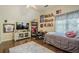 Spacious bedroom with a ceiling fan, featuring a large TV, desk, and shelving at 2566 Garrison Sw, Marietta, GA 30064
