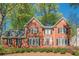 Charming red brick home with black shutters, white trim, and flowering bushes in a well-maintained front yard at 2566 Garrison Sw, Marietta, GA 30064