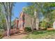Side view of a two-story home with brick and siding, black shutters, and a well-kept lawn at 2566 Garrison Sw, Marietta, GA 30064