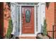 Elegant front entrance featuring a wood door with decorative glass, flanked by sidelights and potted plants at 2566 Garrison Sw, Marietta, GA 30064