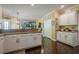 Spacious kitchen with white cabinets, granite countertops, and dark hardwood floors, seamlessly connects to other living spaces at 2566 Garrison Sw, Marietta, GA 30064