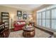 Cozy living room features a red sofa, a round coffee table, a piano, and bright windows with white shutters at 2566 Garrison Sw, Marietta, GA 30064