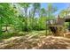 Beautiful backyard with lush lawn, mature trees, and a raised deck with stairs at 4415 Dorset Ln, Suwanee, GA 30024