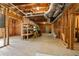 Unfinished basement with concrete floors, exposed beams, shelving, and utility hookups at 4415 Dorset Ln, Suwanee, GA 30024