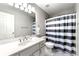 Bathroom with modern vanity, a mirror, contrasting striped shower curtain, and tile flooring at 4415 Dorset Ln, Suwanee, GA 30024