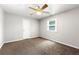 Bedroom with ceiling fan, double door closet, neutral walls and carpet, and a backyard view at 4415 Dorset Ln, Suwanee, GA 30024