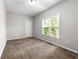Cozy bedroom featuring neutral carpet, a window with natural light, and a spacious closet at 4415 Dorset Ln, Suwanee, GA 30024