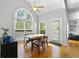 Dining room with hardwood floors, high ceilings, arched window overlooking the yard, and modern dining set at 4415 Dorset Ln, Suwanee, GA 30024