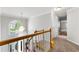 Bright hallway features hardwood railings, neutral walls, and a decorative light fixture over the staircase at 4415 Dorset Ln, Suwanee, GA 30024