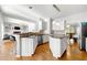 Open kitchen featuring hardwood floors, granite countertops, island, and seamless flow into the living and dining areas at 4415 Dorset Ln, Suwanee, GA 30024