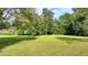 The large green lawn has beautiful, mature trees at 5690 Abbotts Bridge Rd, Johns Creek, GA 30097