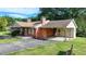 The home features a brick exterior, a side carport, and a well-maintained lawn at 5690 Abbotts Bridge Rd, Johns Creek, GA 30097