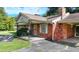 Close-up view of a quaint brick home featuring a covered front porch at 5690 Abbotts Bridge Rd, Johns Creek, GA 30097