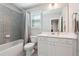 Bathroom featuring a shower/tub combo, toilet, window, and vanity with drawers and cabinet at 787 Belrose Dr, Smyrna, GA 30080