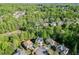 Aerial view of a beautiful neighborhood surrounded by lush greenery and mature trees at 5093 Heartland Trl, Hoschton, GA 30548