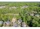 Aerial view of a beautiful neighborhood surrounded by lush greenery and mature trees at 5093 Heartland Trl, Hoschton, GA 30548