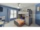A bedroom with a bunk bed set, blue walls, and a window with plaid curtains, perfect for fun and relaxation at 5093 Heartland Trl, Hoschton, GA 30548