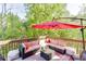 Outdoor deck with plush patio furniture and sun umbrella at 5093 Heartland Trl, Hoschton, GA 30548