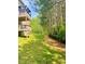 A grassy backyard with a partially visible wooden deck and a treelined property line at 4346 Traipse Path, Ellenwood, GA 30294