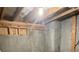 Basement with exposed concrete wall, unfinished ceiling with beams, and visible utilities in an unfinished space at 4346 Traipse Path, Ellenwood, GA 30294