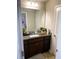 Bathroom featuring a dark vanity with granite counter and a decorative mirror at 4346 Traipse Path, Ellenwood, GA 30294