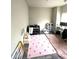 bedroom features a pink rug, crib, and plenty of room for activities and storage at 4346 Traipse Path, Ellenwood, GA 30294