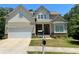 Charming two-story home featuring a brick-accented facade, attached garage, and a well-maintained front yard at 4346 Traipse Path, Ellenwood, GA 30294