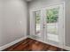 Bright room with hardwood floors featuring white framed patio doors and outside view at 6023 Brookside Oak Cir, Norcross, GA 30093