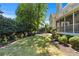 Well-manicured backyard featuring lush landscaping and a charming screened porch at 605 Tatum Ct, Alpharetta, GA 30022