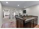 Basement bar with granite countertop and dark wood cabinetry, connecting to a recreational area through arched openings at 605 Tatum Ct, Alpharetta, GA 30022