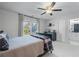 Neutral bedroom with ceiling fan, bright window, and adjacent bathroom at 605 Tatum Ct, Alpharetta, GA 30022