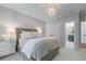 Neutral bedroom featuring a comfy bed, mirrored nightstand, chandelier and ensuite bathroom at 605 Tatum Ct, Alpharetta, GA 30022